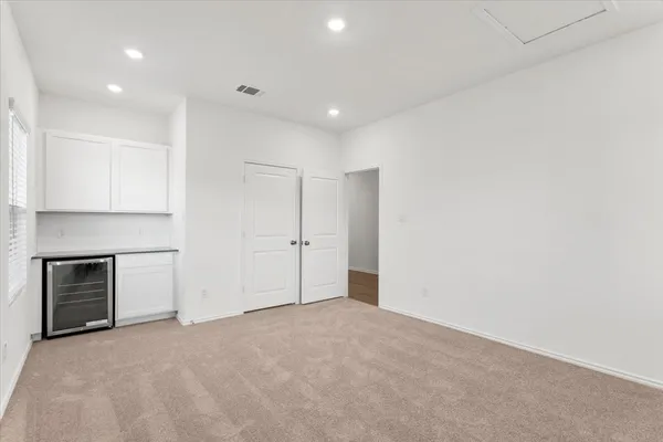 a view of an empty room with closet and a window