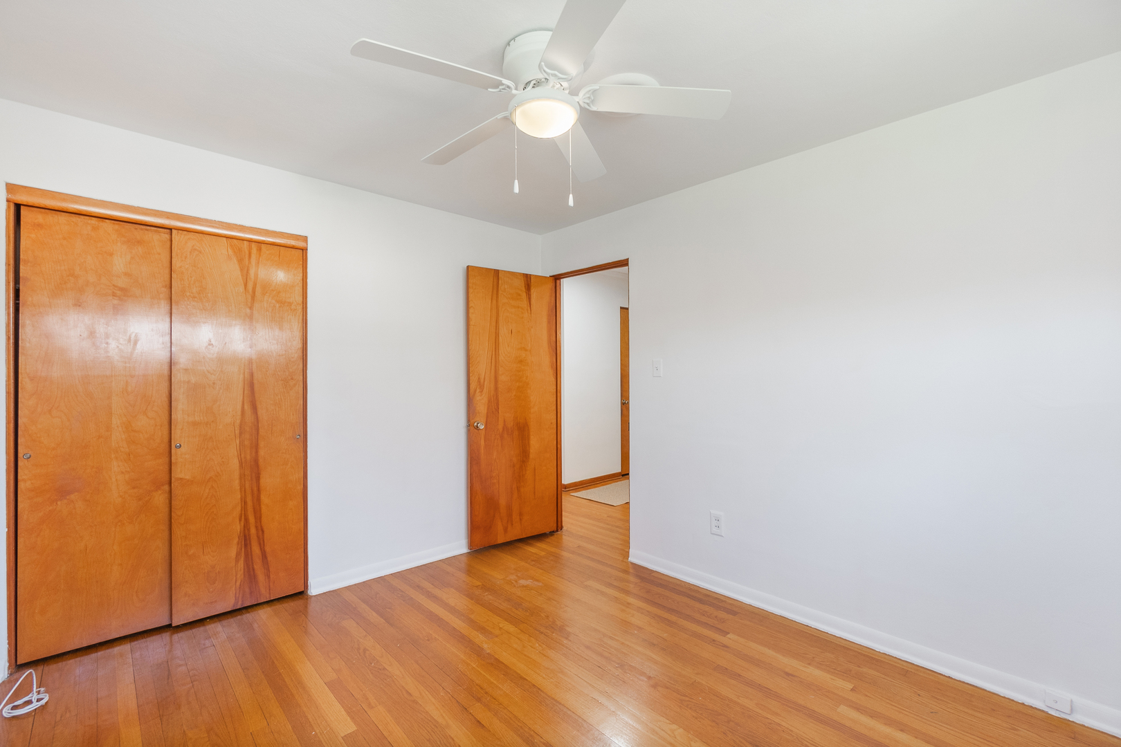 3225 Otto Street Lansing, IL 60438 - Photo 11 of 21 an empty room with wooden floor and a ceiling fan
