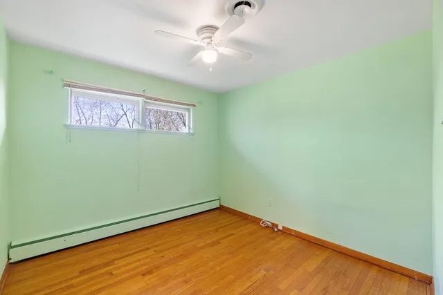 an empty room with a ceiling fan and a window