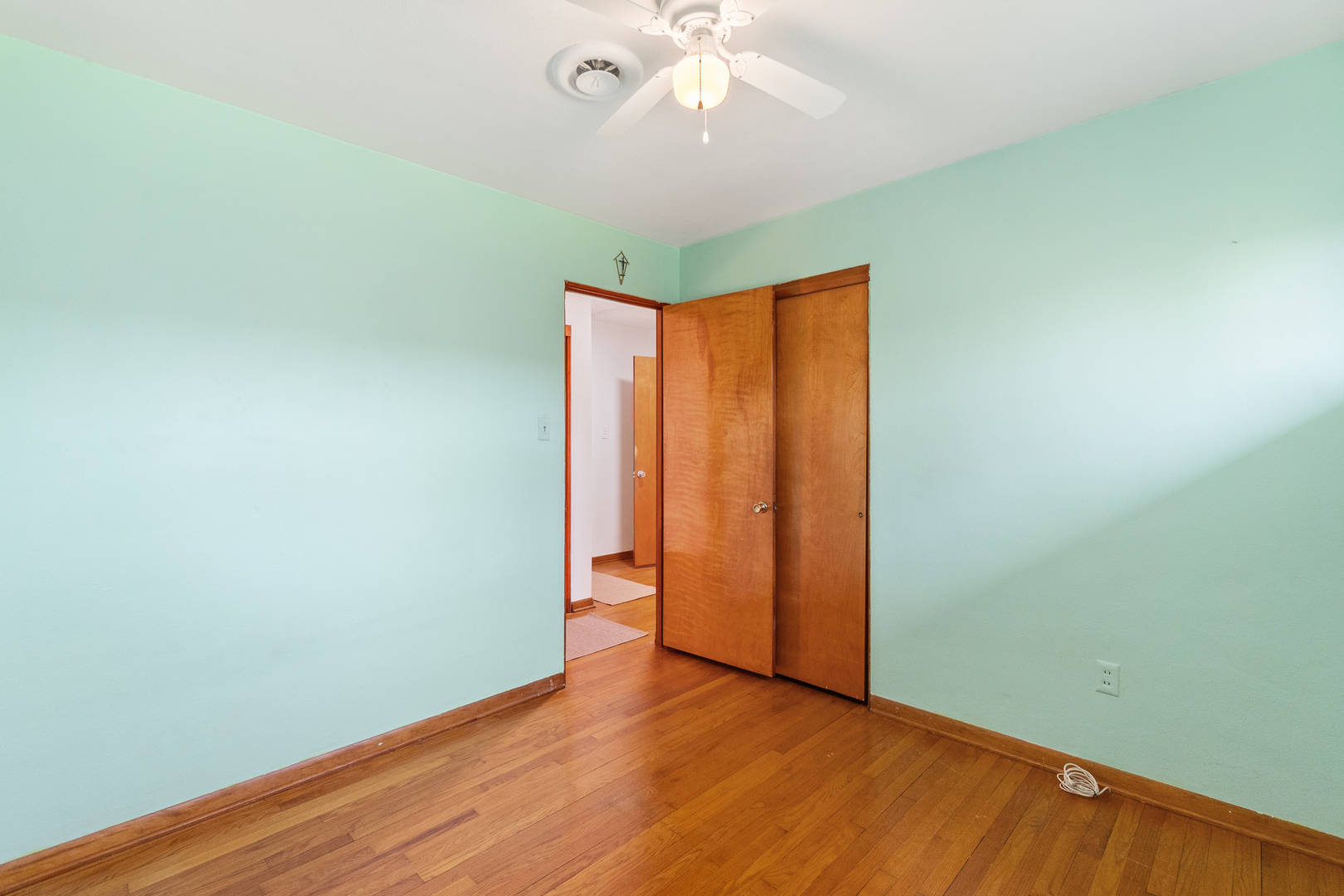 3225 Otto Street Lansing, IL 60438 - Photo 13 of 21 an empty room with wooden floor and fan