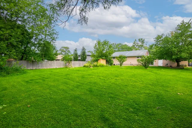 a view of a house with a big yard and potted plants