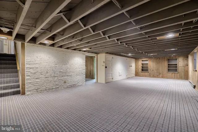 a front view of a house with a garden and trees