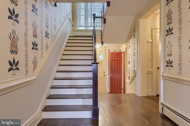 a view of an empty room with wooden floor and window