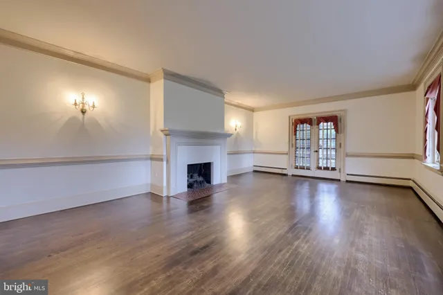 a view of empty room with wooden floor and fireplace