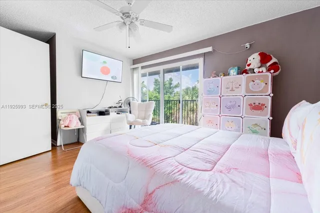 a bedroom with a bed a chandelier and a large window