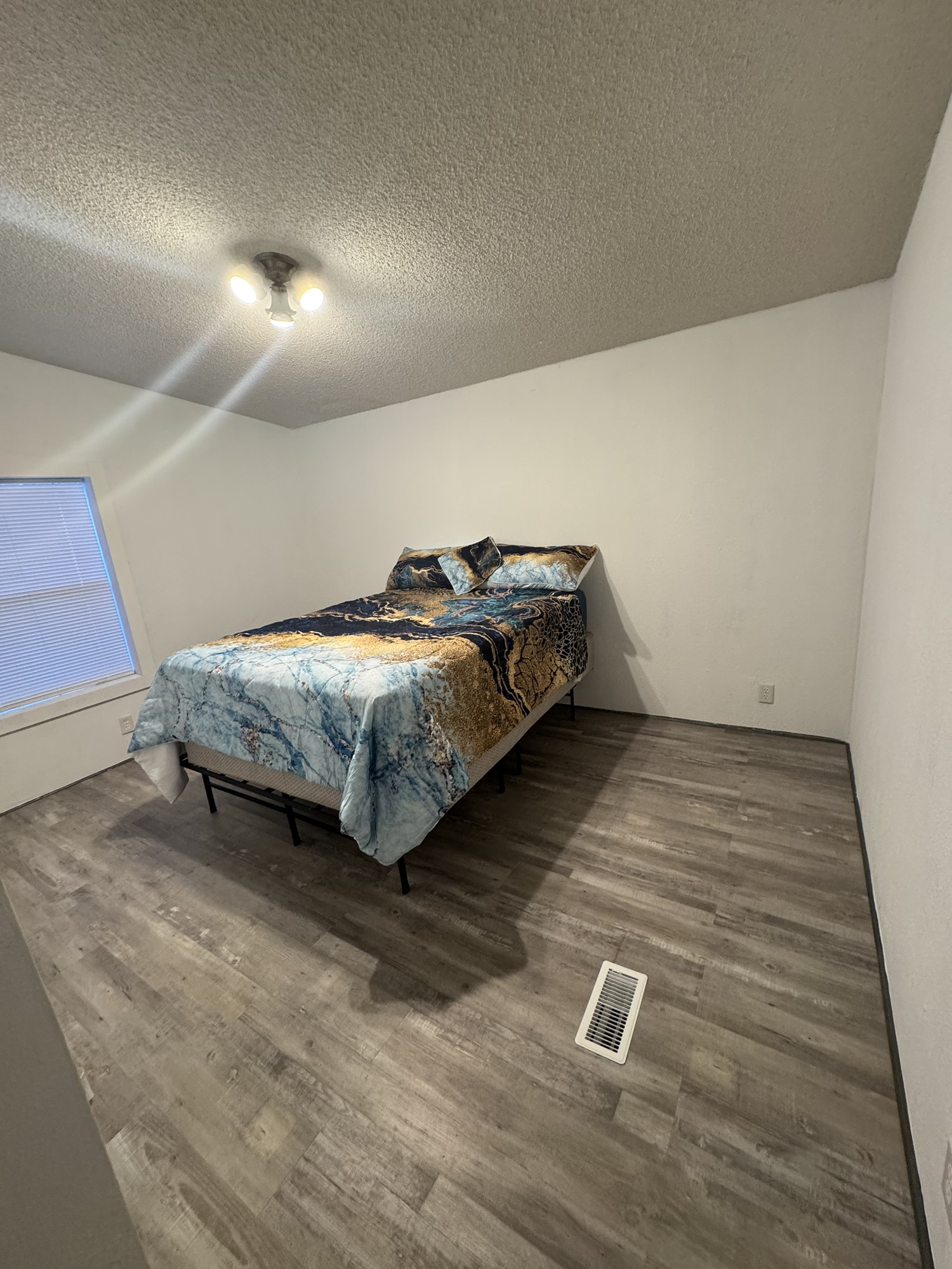 70 Timber Road Point Blank, TX 77364 - Photo 15 of 20 a spacious bedroom with a bed and a wooden floor