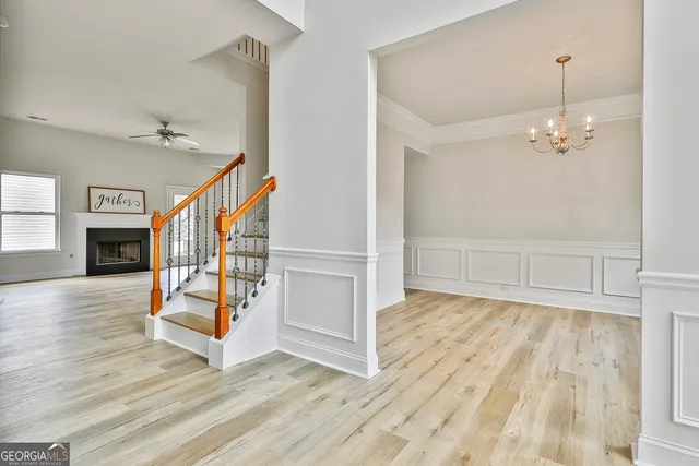 an empty room with wooden floor fireplace and windows