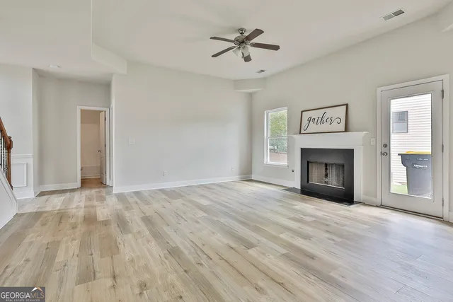 a view of empty room with wooden floor and fireplace
