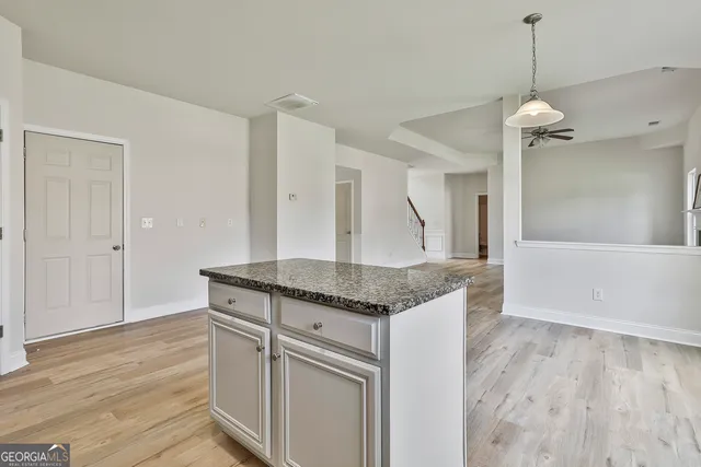a kitchen with granite countertop a stove and a wooden floor