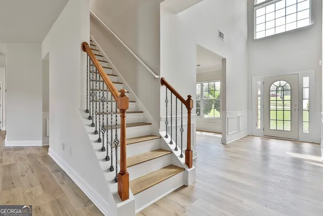 a view of staircase with wooden floor and a large window