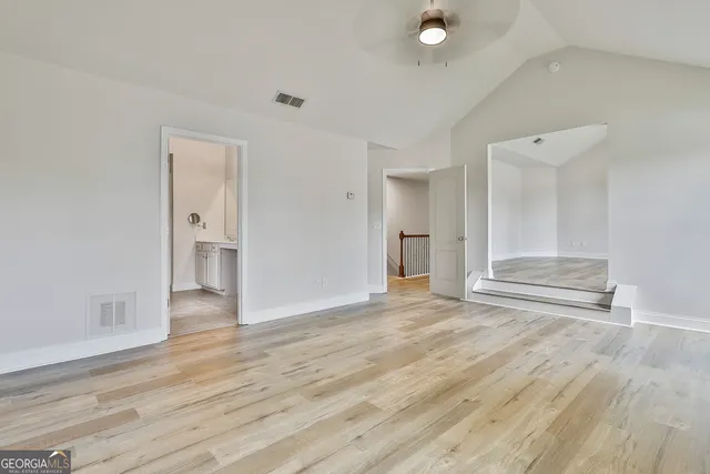 a view of empty room with wooden floor and entryway