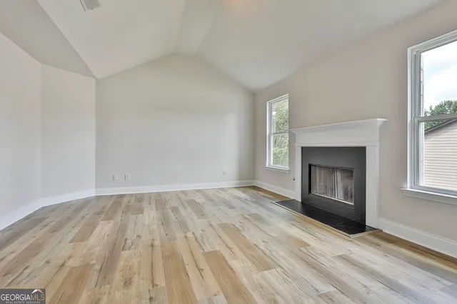 wooden floor fireplace and windows in an empty room