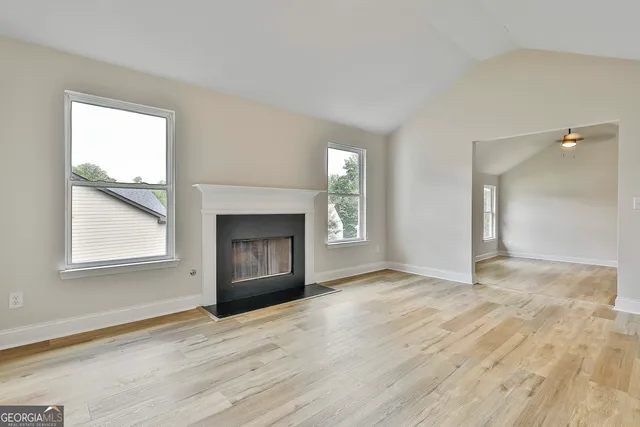 wooden floor fireplace and windows in an empty room
