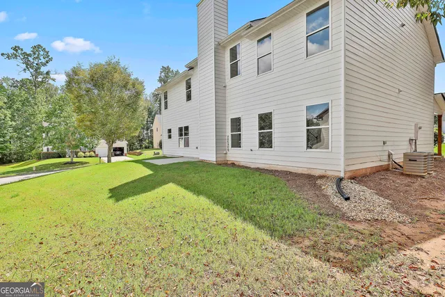 a view of a house with backyard and trees