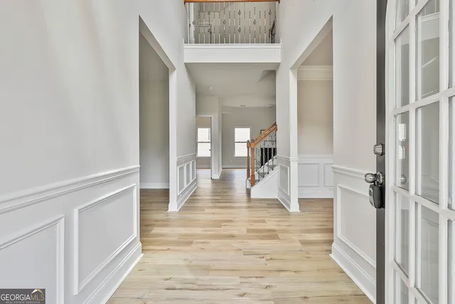 a view of a hallway with wooden floor and staircase