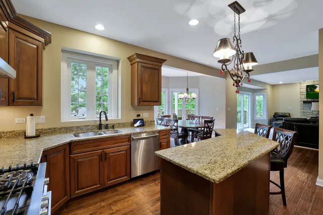 a kitchen with granite countertop kitchen island a sink cabinets and appliances