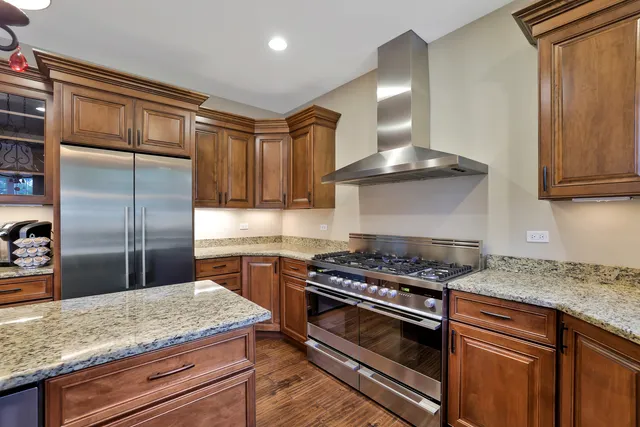 a kitchen with granite countertop stainless steel appliances and wooden cabinets