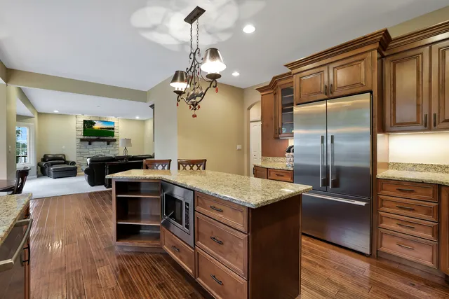 a kitchen with stainless steel appliances granite countertop a sink refrigerator and cabinets