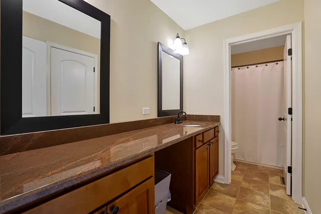 a bathroom with a granite countertop sink and a mirror