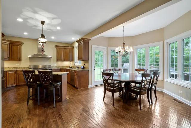 a view of a dining room and livingroom with furniture wooden floor a chandelier
