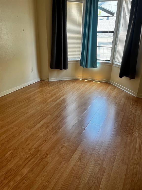 915 West 23rd Street, Unit 108 Austin, TX 78705 - Photo 13 of 14 an empty room with wooden floor and windows