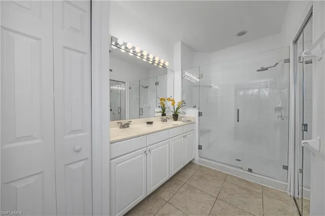 a bathroom with a double vanity sink mirror and shower