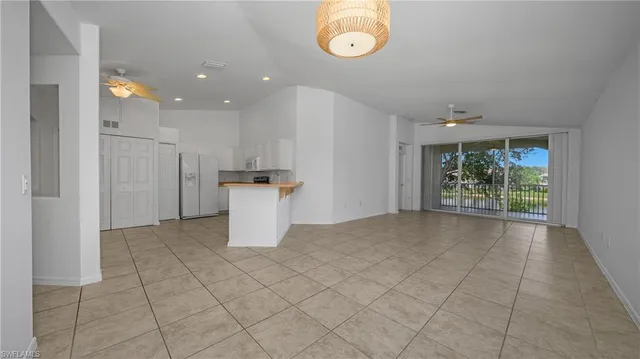an empty room & kitchen with a window refrigerator