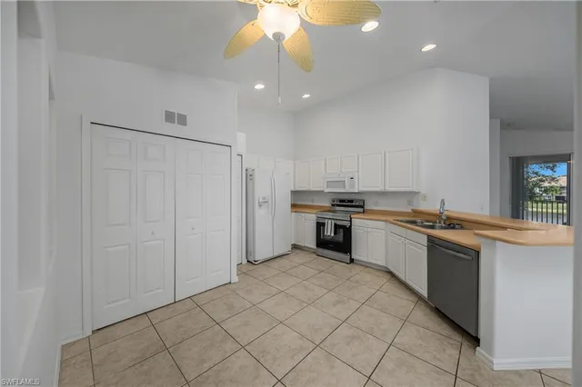 a large kitchen with kitchen island a sink stainless steel appliances and cabinets