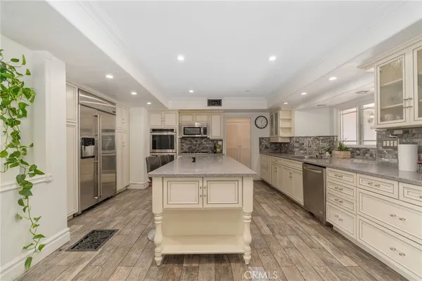 a kitchen with stainless steel appliances kitchen island granite countertop a stove and a refrigerator
