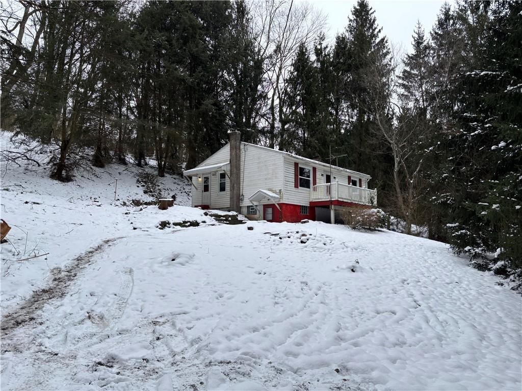 a view of white house with a yard covered in snow
