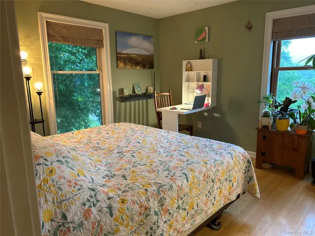 a bedroom with a bed and a dresser next to a window