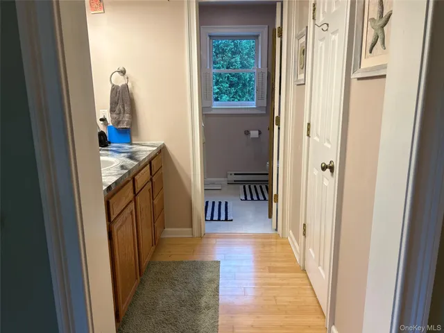 a hallway with wooden floor closet and a window