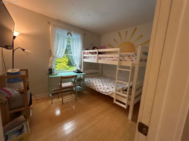 a bedroom with a bunk bed and a chair