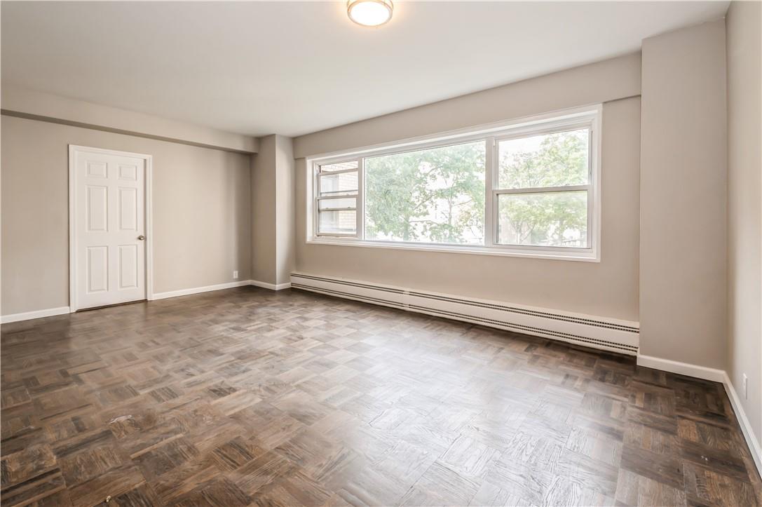 9 Fordham Hill Ovl, Unit 4F Bronx, NY 10468 - Photo 3 of 14 Unfurnished room featuring baseboard heating and dark parquet flooring