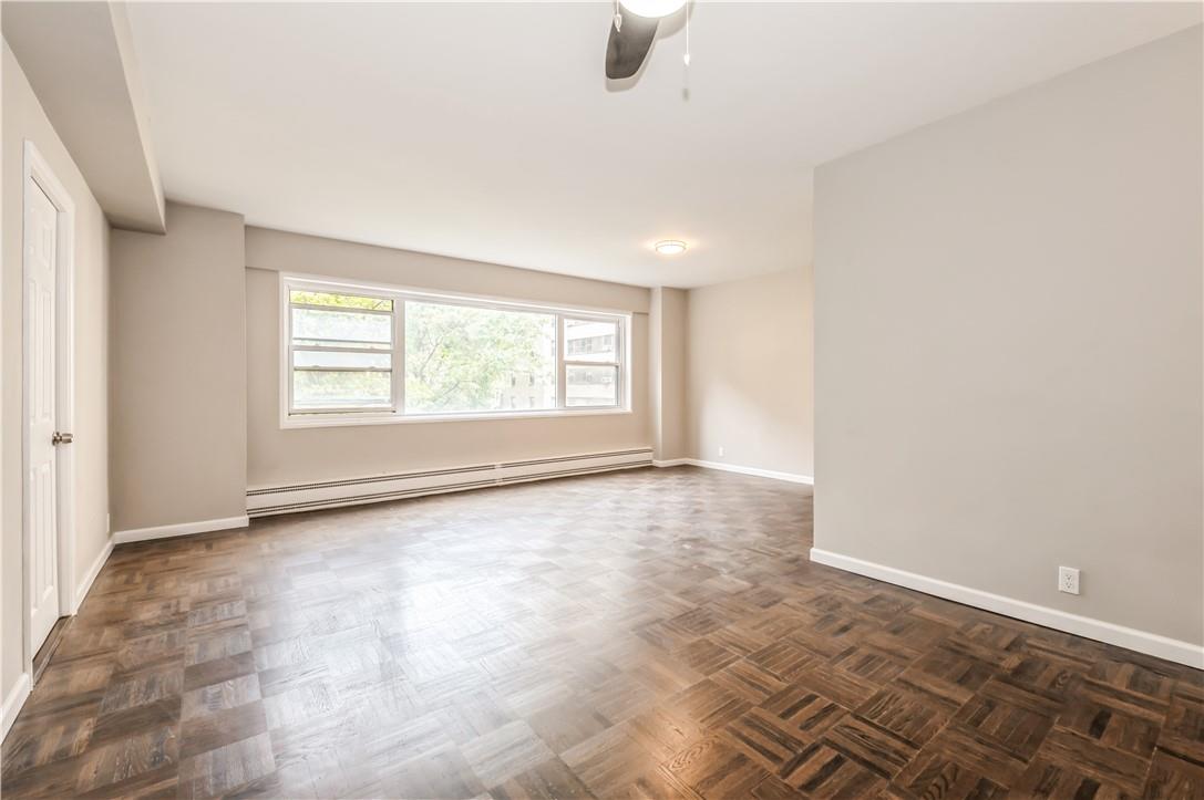 9 Fordham Hill Ovl, Unit 4F Bronx, NY 10468 - Photo 4 of 14 Spare room featuring a baseboard heating unit, dark parquet floors, and ceiling fan