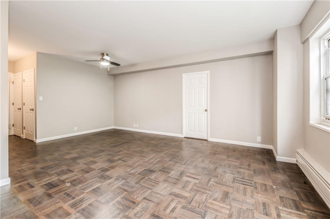 9 Fordham Hill Ovl, Unit 4F Bronx, NY 10468 - Photo 6 of 14 Empty room featuring ceiling fan, baseboard heating, and dark parquet flooring