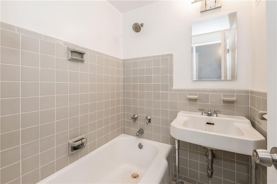 9 Fordham Hill Ovl, Unit 4F Bronx, NY 10468 - Photo 9 of 14 Bathroom featuring tile walls and a bathing tub