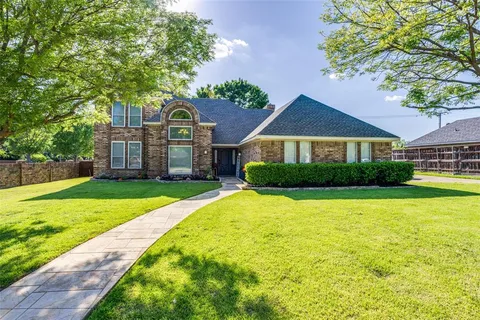 a front view of a house with yard and green space