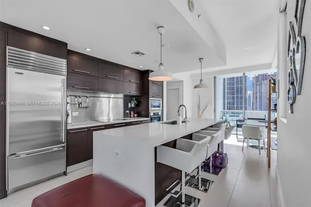 a large kitchen with stainless steel appliances lots of counter space and a sink