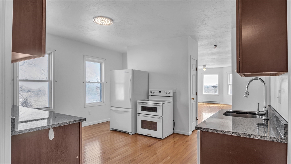 1442 Main Street, Unit 2 Worcester, MA 01603 - Photo 13 of 30 a kitchen with stainless steel appliances granite countertop a sink stove and refrigerator