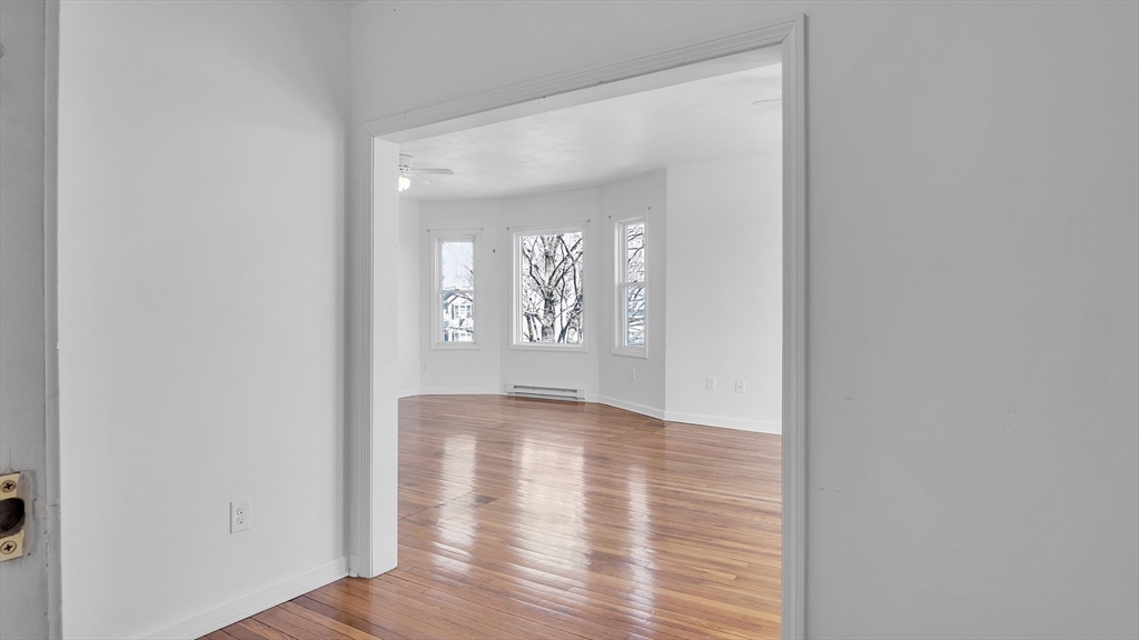 1442 Main Street, Unit 2 Worcester, MA 01603 - Photo 4 of 30 a view of an empty room with wooden floor and a window