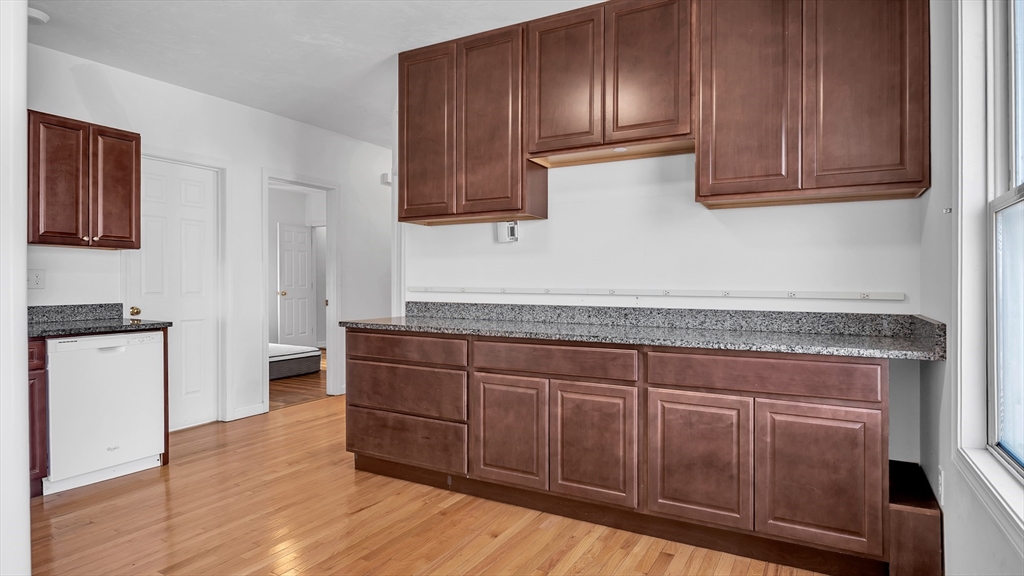 1442 Main Street, Unit 2 Worcester, MA 01603 - Photo 10 of 30 a kitchen with granite countertop wooden cabinets and white appliances