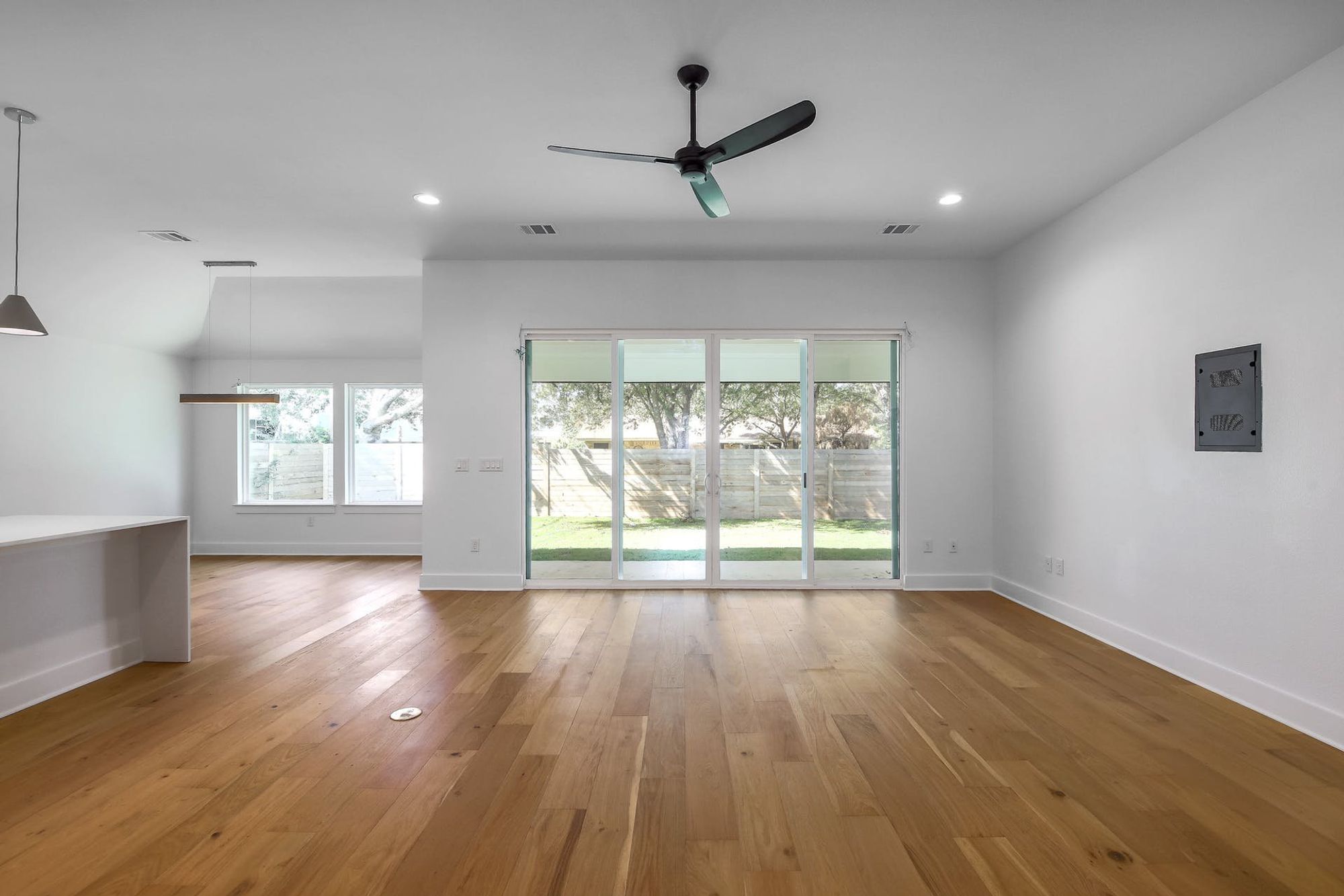 8302 Kromer Street Austin, TX 78757 - Photo 13 of 34 Empty room with ceiling fan, light wood-style floors, and recessed lighting