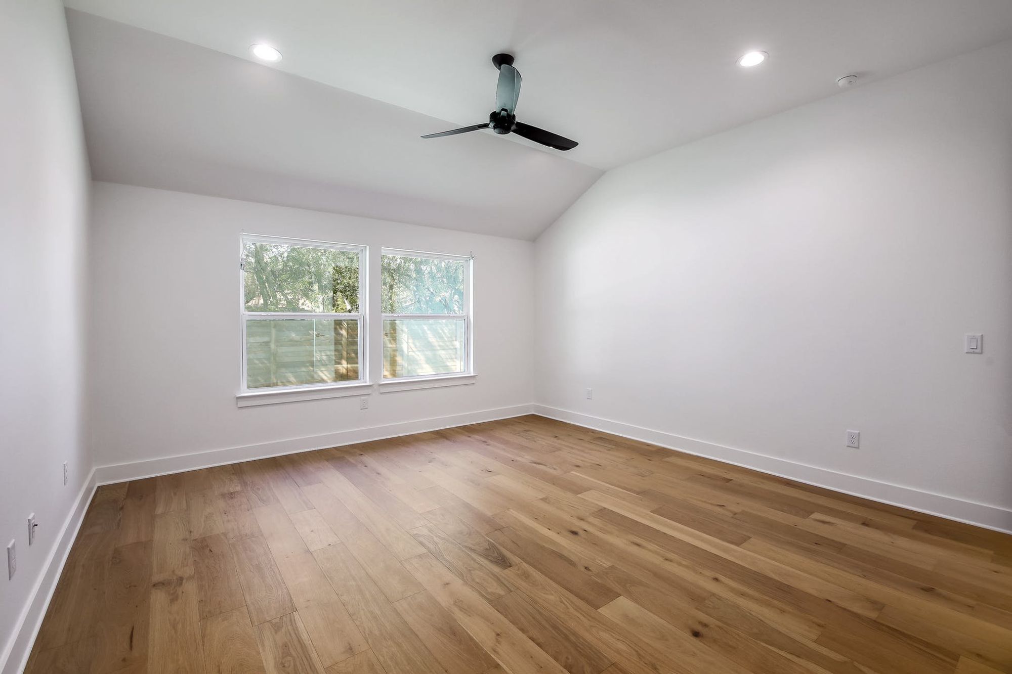 8302 Kromer Street Austin, TX 78757 - Photo 19 of 34 Spare room with light wood-type flooring, a ceiling fan, vaulted ceiling, and recessed lighting