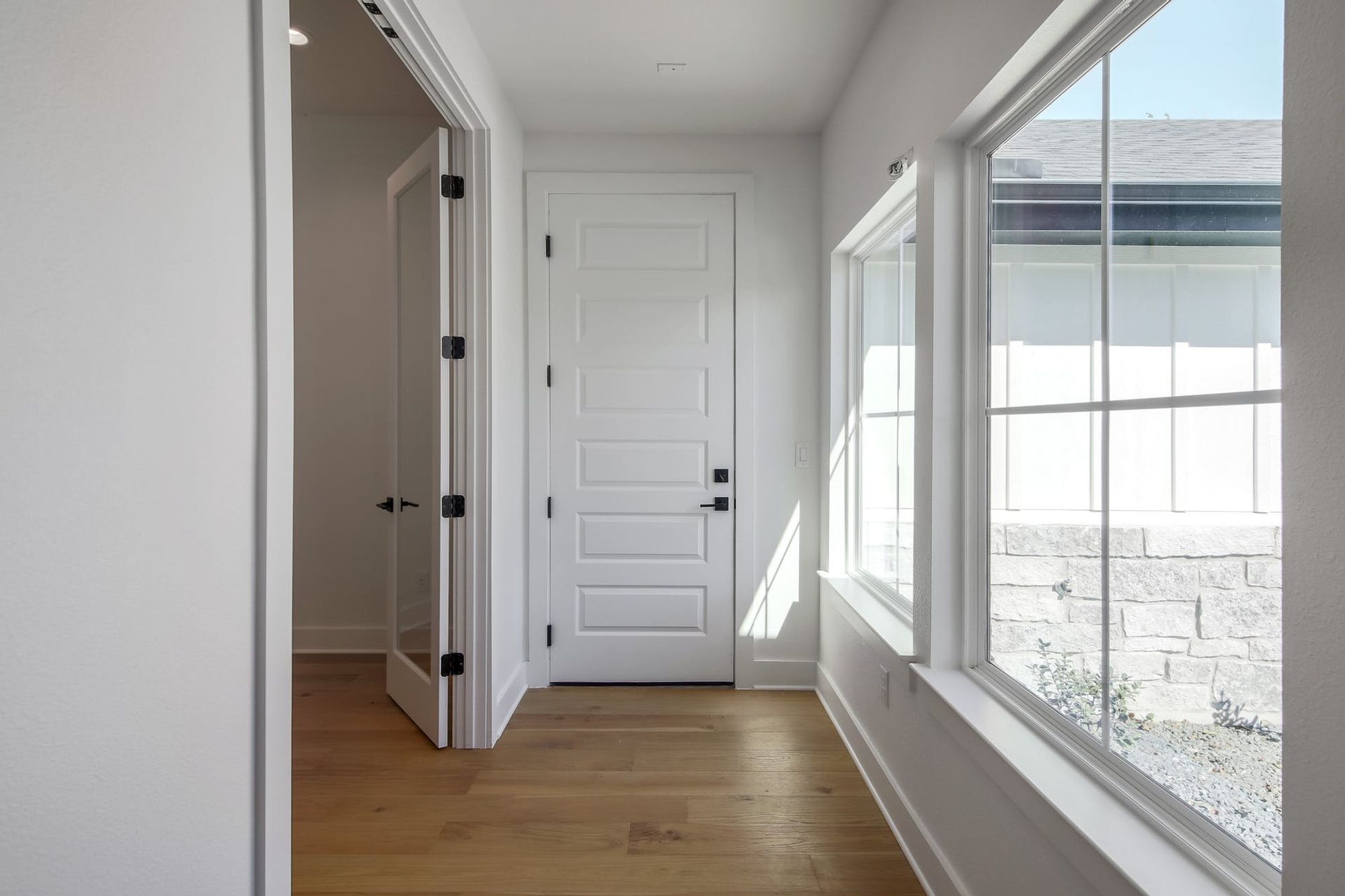 8302 Kromer Street Austin, TX 78757 - Photo 26 of 34 Hallway with light wood finished floors and baseboards
