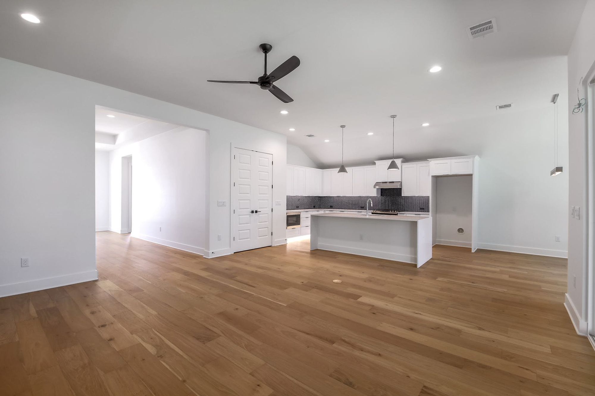 8302 Kromer Street Austin, TX 78757 - Photo 32 of 34 Kitchen featuring open floor plan, white cabinetry, a kitchen island with sink, light countertops, and a ceiling fan
