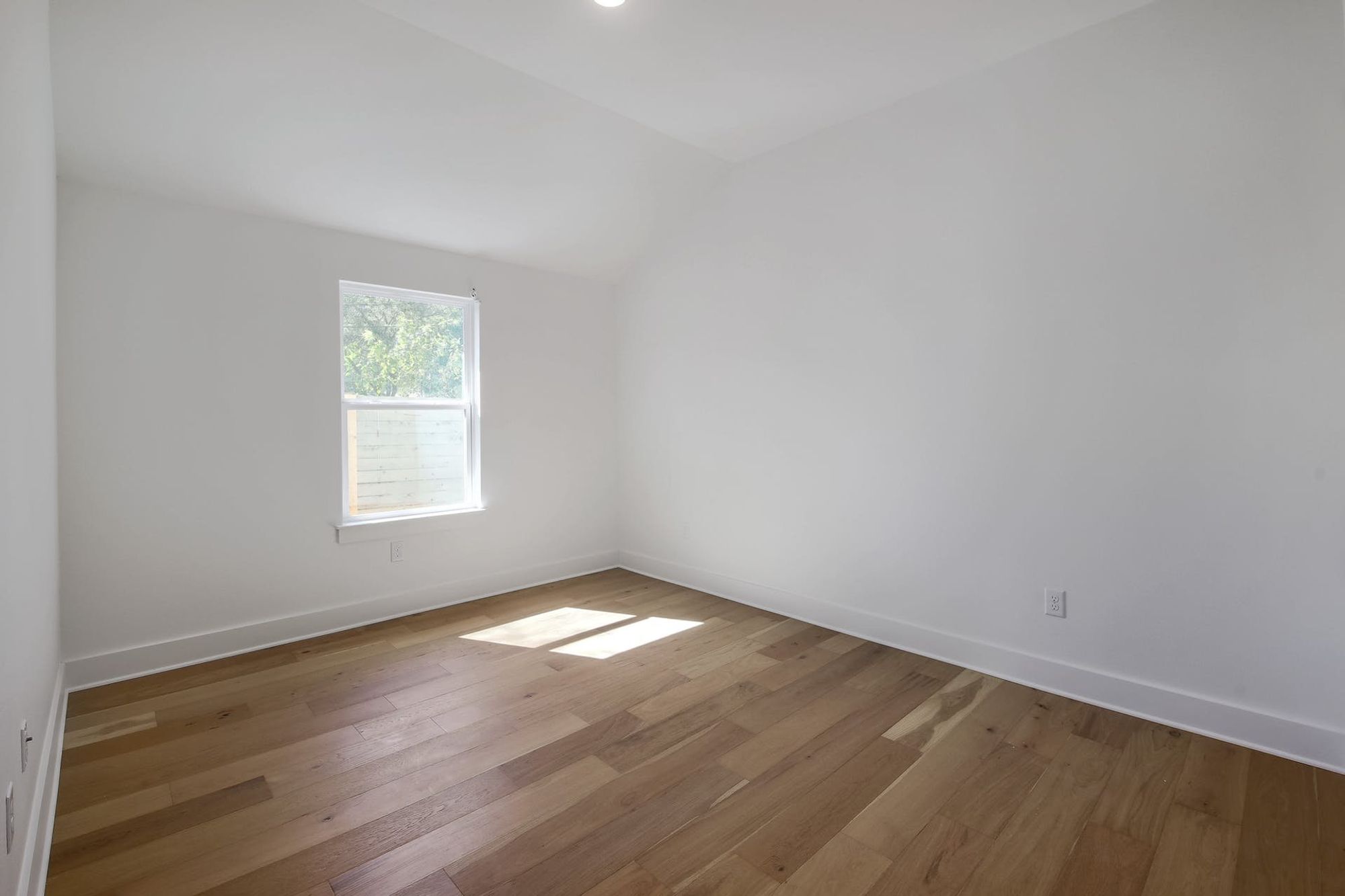 8302 Kromer Street Austin, TX 78757 - Photo 7 of 34 Unfurnished room featuring lofted ceiling and light wood finished floors