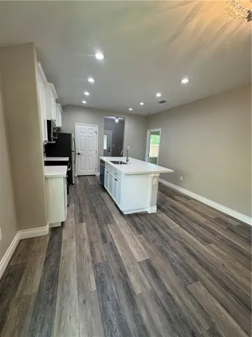 a view of kitchen with cabinets stainless steel appliances with wooden floor
