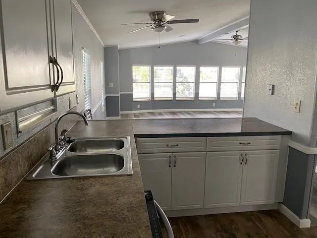 a kitchen with granite countertop a sink stove and cabinets
