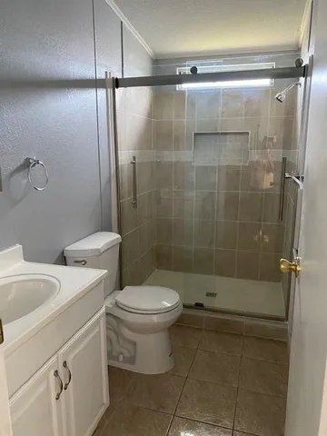 a bathroom with a shower a toilet and sink